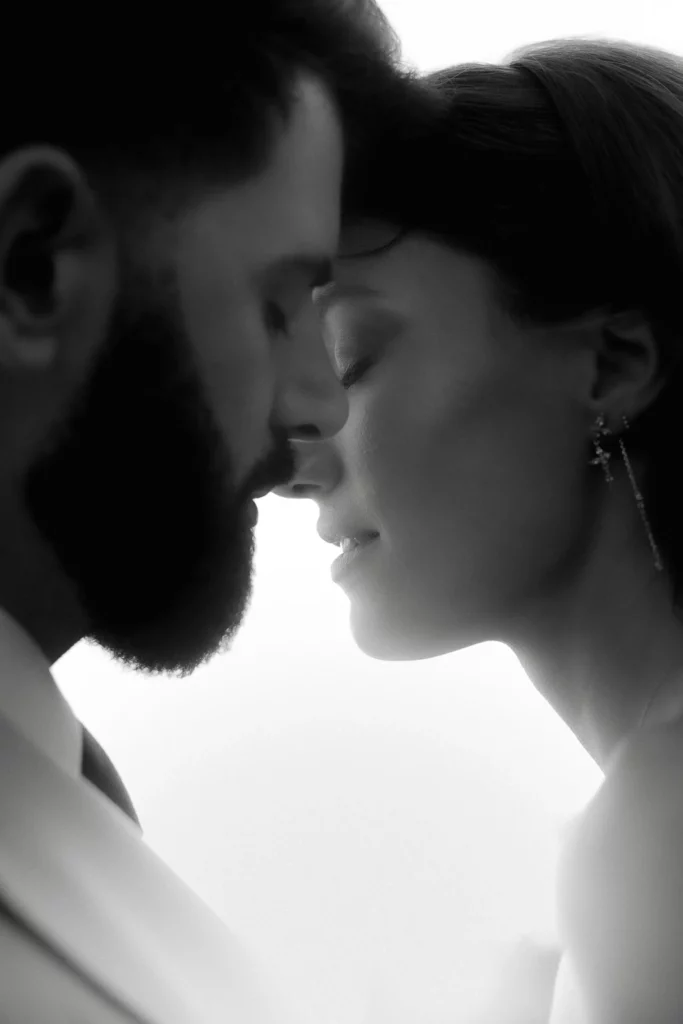 In Puglia, a tender black and white moment as a couple gently touch foreheads, eyes closed in serene connection.