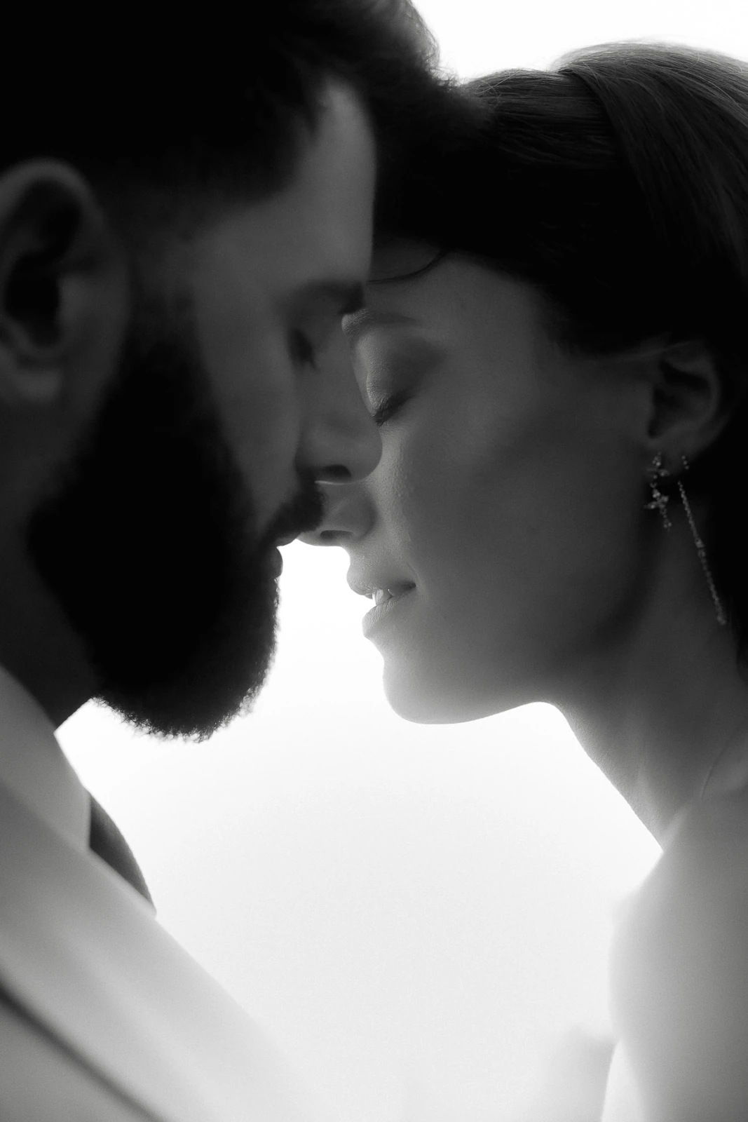 In Puglia, a tender black and white moment as a couple gently touch foreheads, eyes closed in serene connection.
