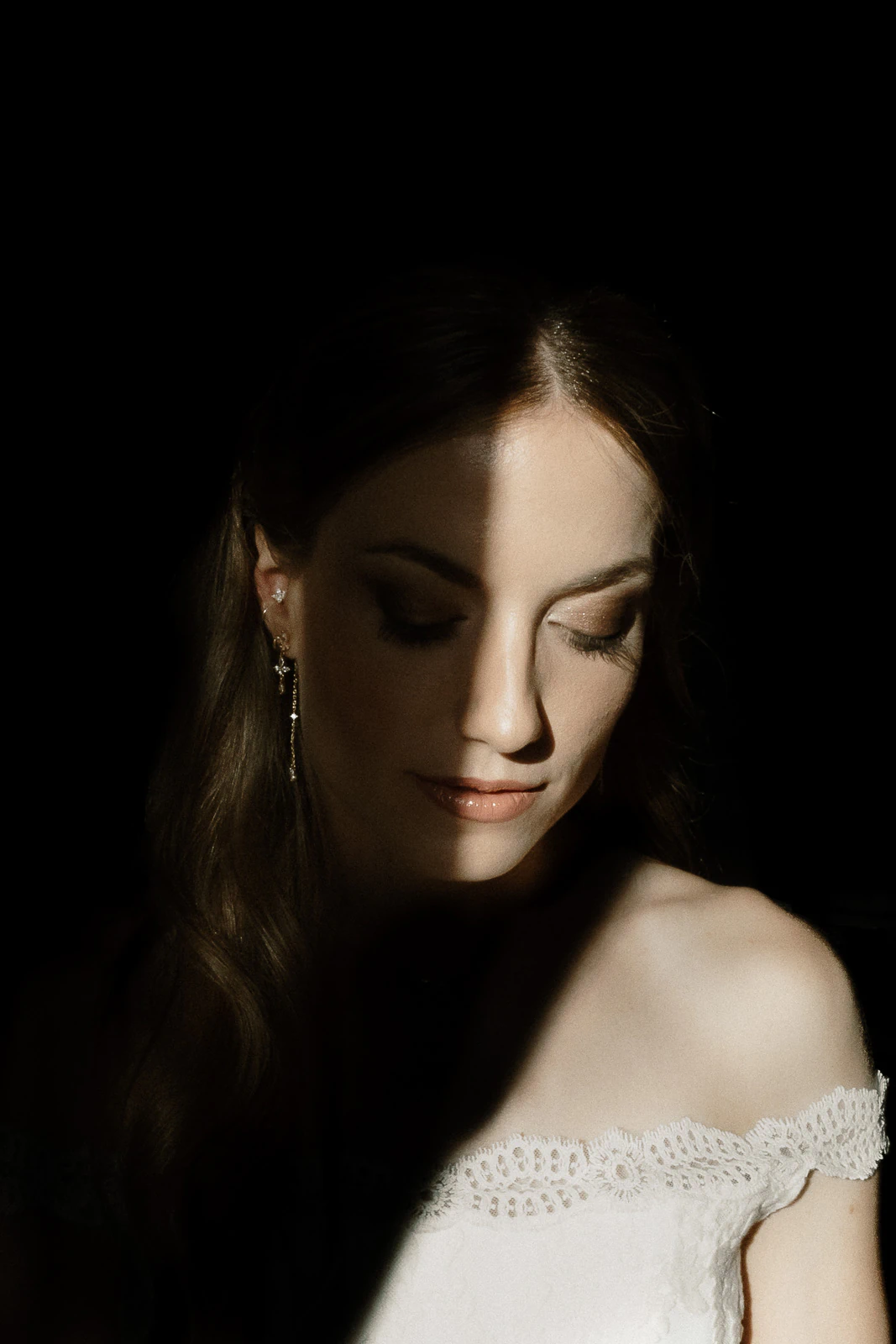 Bathed in golden light, a bride's serene gaze glows against the shadows—capturing timeless elegance in Puglia, Italy.