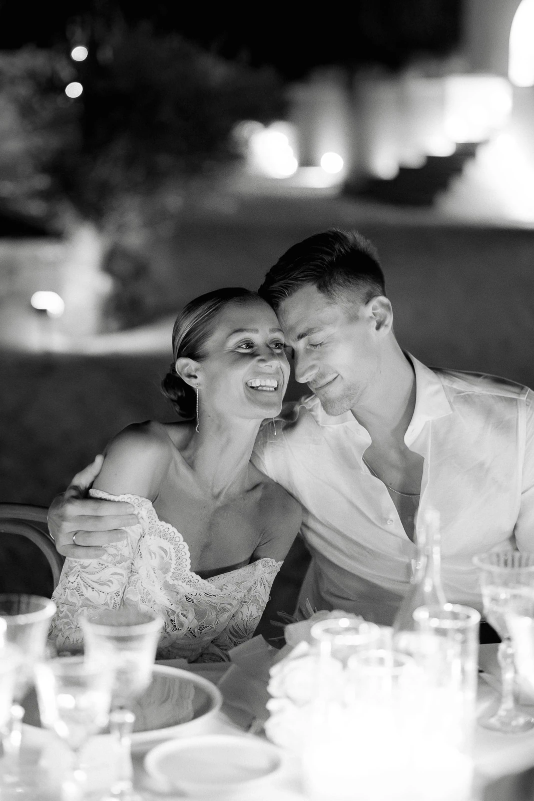 In Puglia, a couple shares an intimate moment by candlelight, surrounded by the timeless romance of an Italian evening.