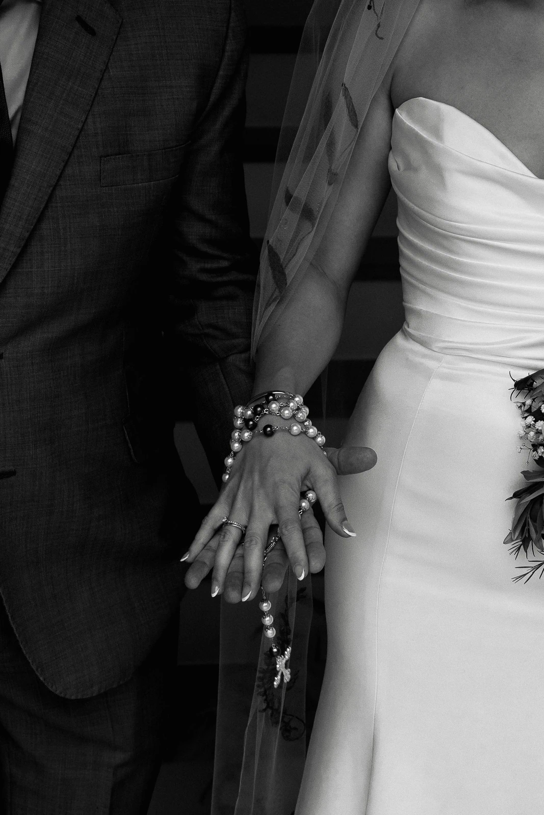 In sunlit Puglia, a couple stands hand in hand—her strapless gown and rosary beads reflecting timeless Italian romance.