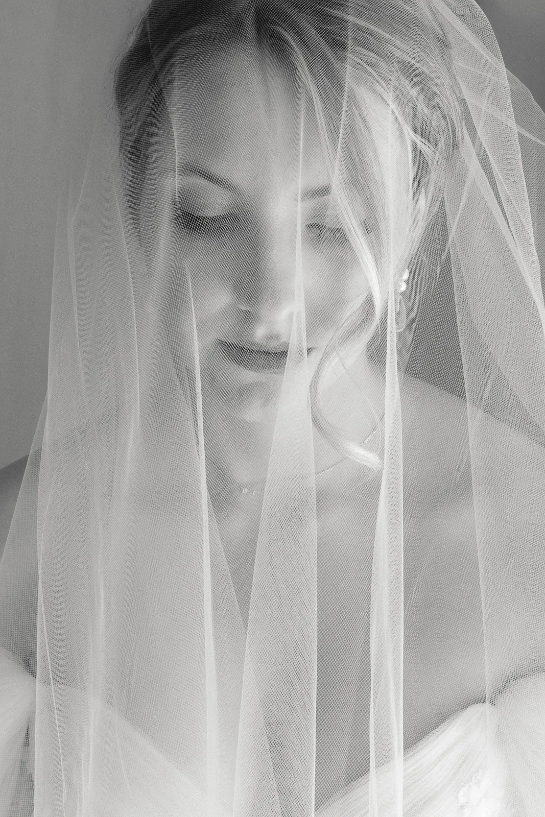 In Puglia, a bride gazes softly downward, her features delicately veiled, evoking serene romance and Italian elegance.