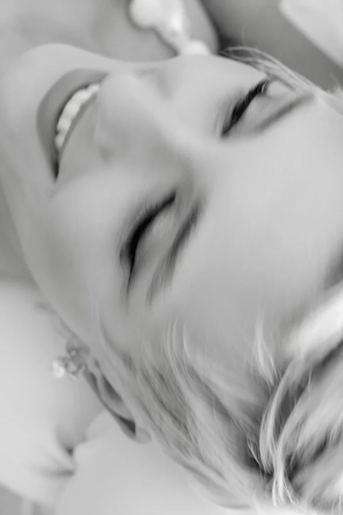 A serene, sunlit moment in Puglia—eyes closed, soft smile—captured in timeless black and white from above.