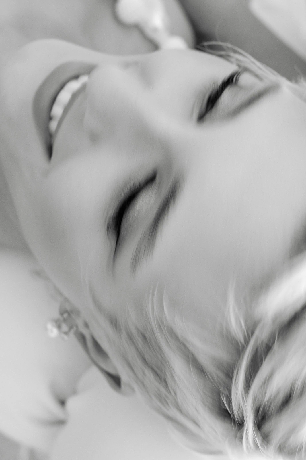 A serene, sunlit moment in Puglia—eyes closed, soft smile—captured in timeless black and white from above.