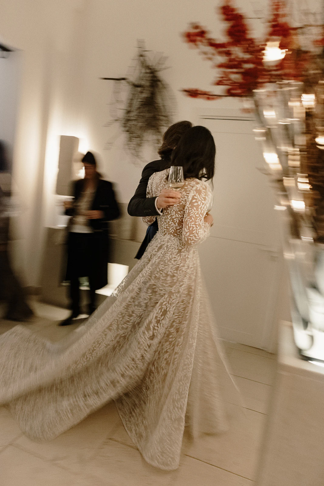 An elegant couple strolls hand-in-hand indoors, her patterned gown flowing—capturing the romantic ambiance of a wedding in Puglia.