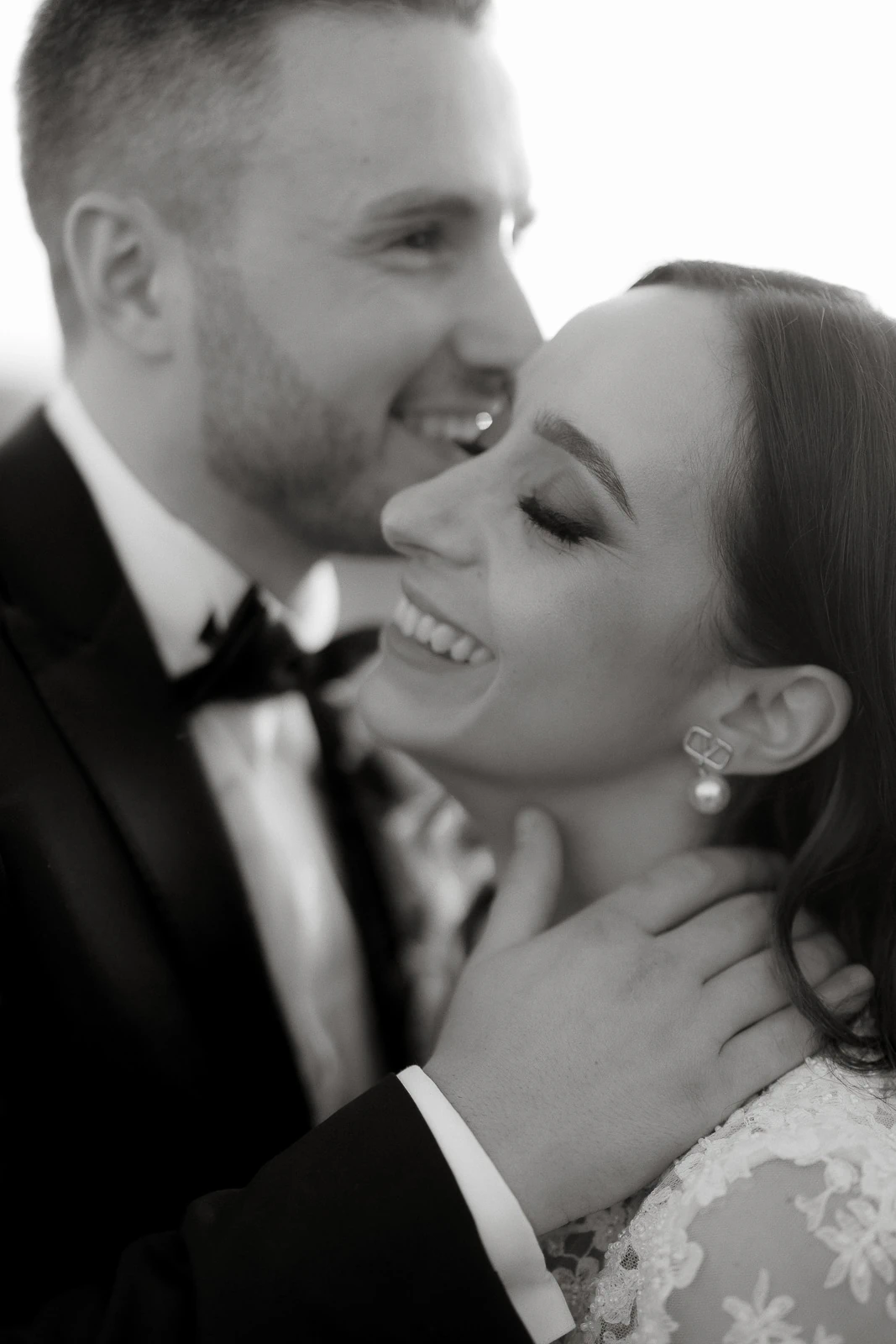 In timeless black and white, a joyous embrace captures the romantic spirit of newlyweds in enchanting Puglia, Italy.