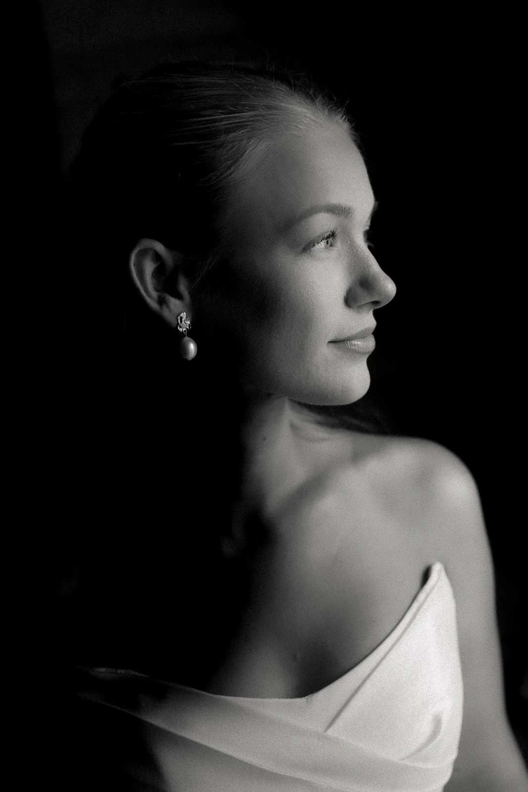 Elegant in Puglia, a bride in a strapless gown gazes softly, light caressing her features with timeless Italian romance.