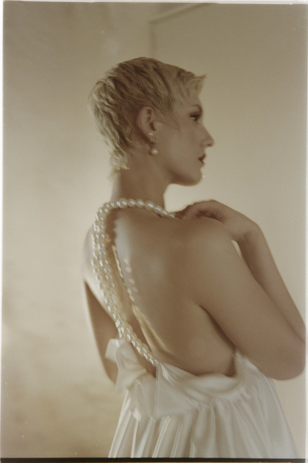 Beneath the golden Puglian light, a bride’s pearl strands cascade over her open-back gown in effortless elegance.