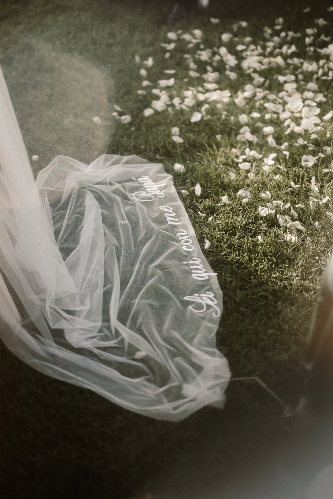 In Puglia, a delicate white veil embroidered with “So, what are we now?” rests gently on petals-strewn grass.