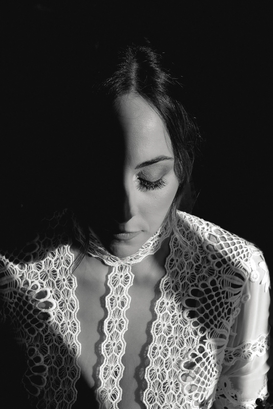 Bathed in evocative light, a bride in lace closes her eyes, serene amid Puglia’s romantic Italian ambiance.